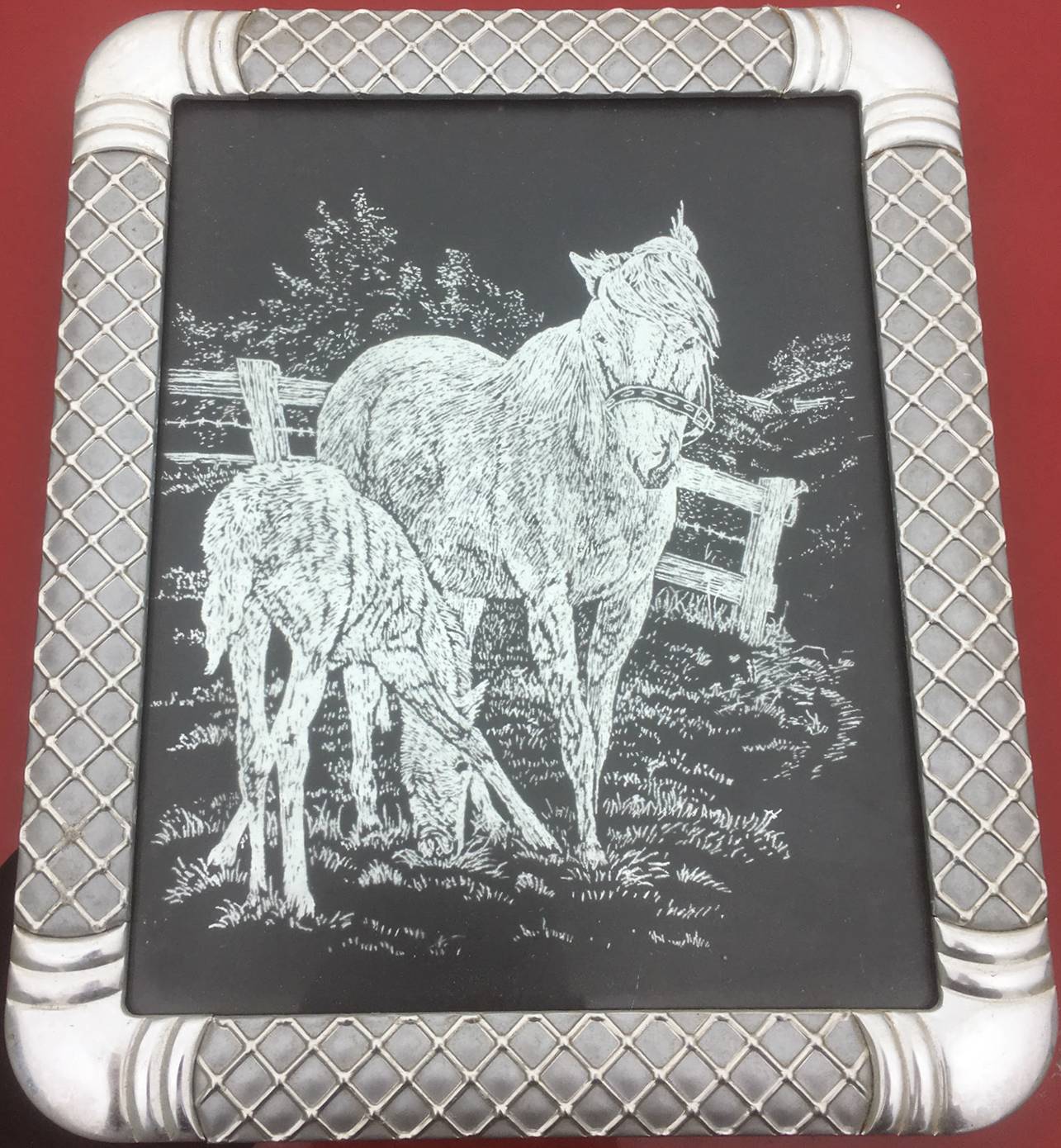 a mother horse and foal engraved into a silver sheet